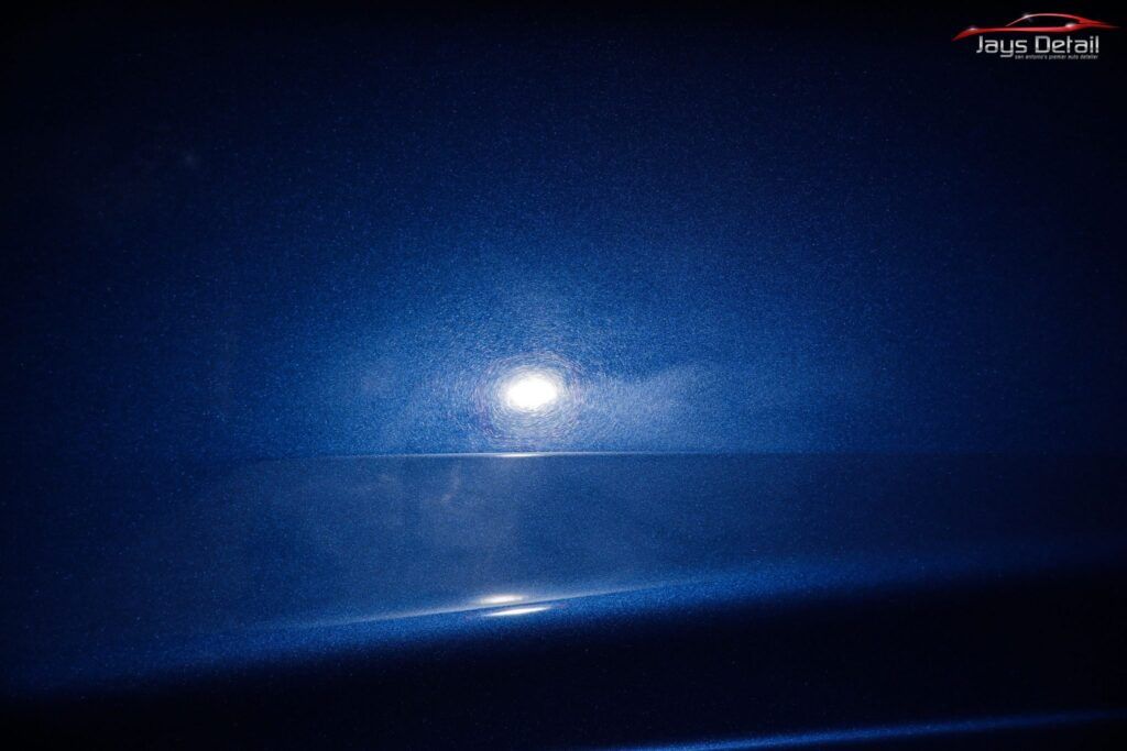 Moon reflecting on the water under a dark blue sky.