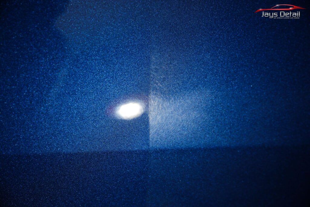 Blue car paint, one side with defects, other side polished. Light reflection in the center.