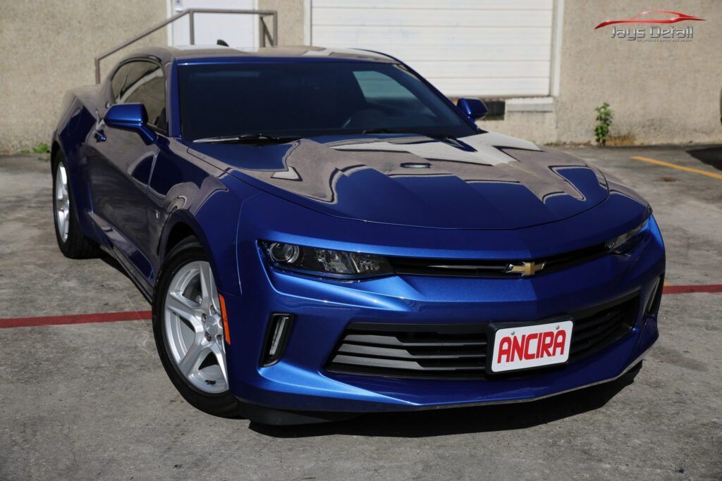Blue Chevrolet Camaro parked in front of a building.