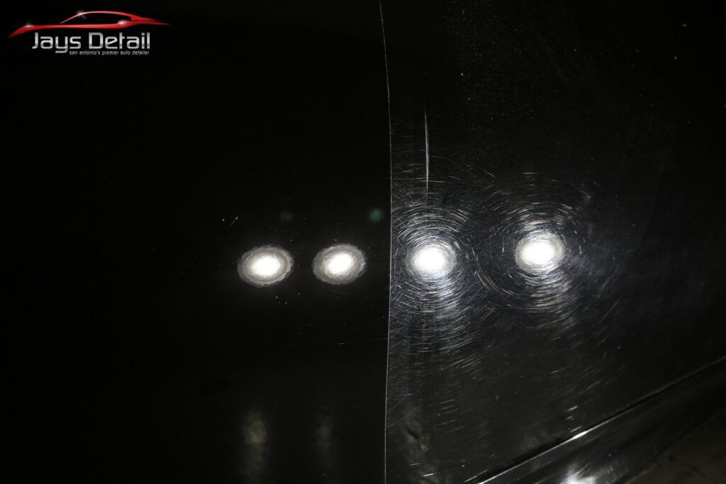 Comparison of a car's black paint: dull on the left, polished and reflective on the right, with light reflections.