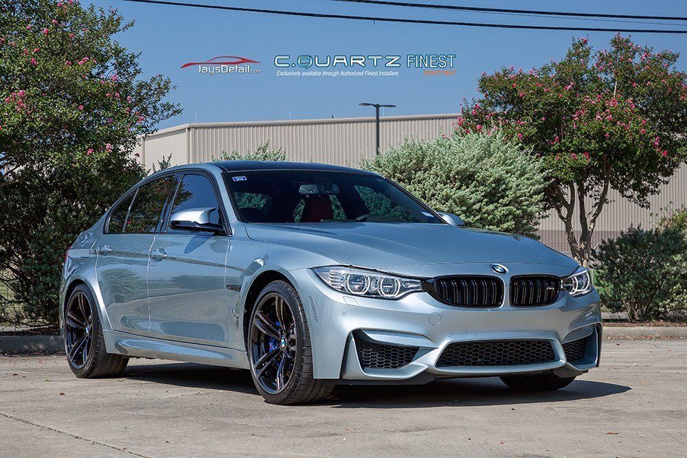 Silver BMW M3 sedan parked outside with black rims, on a sunny day.