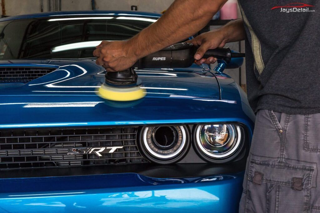 Silver BMW being covered with protective film.
