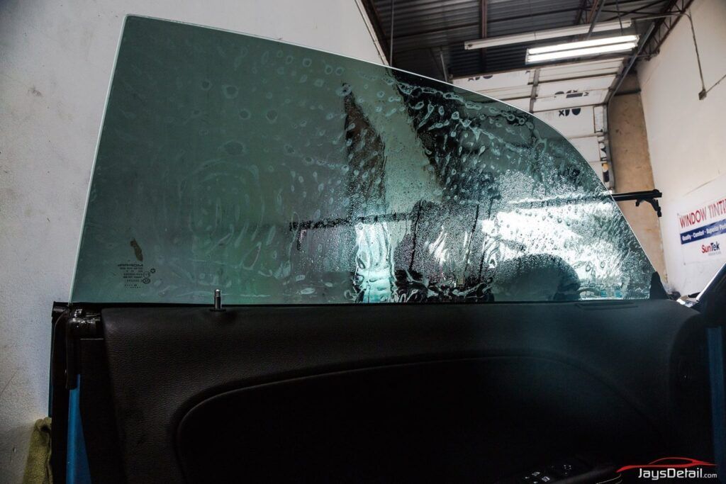 Car door with tinted window, in an auto repair shop.