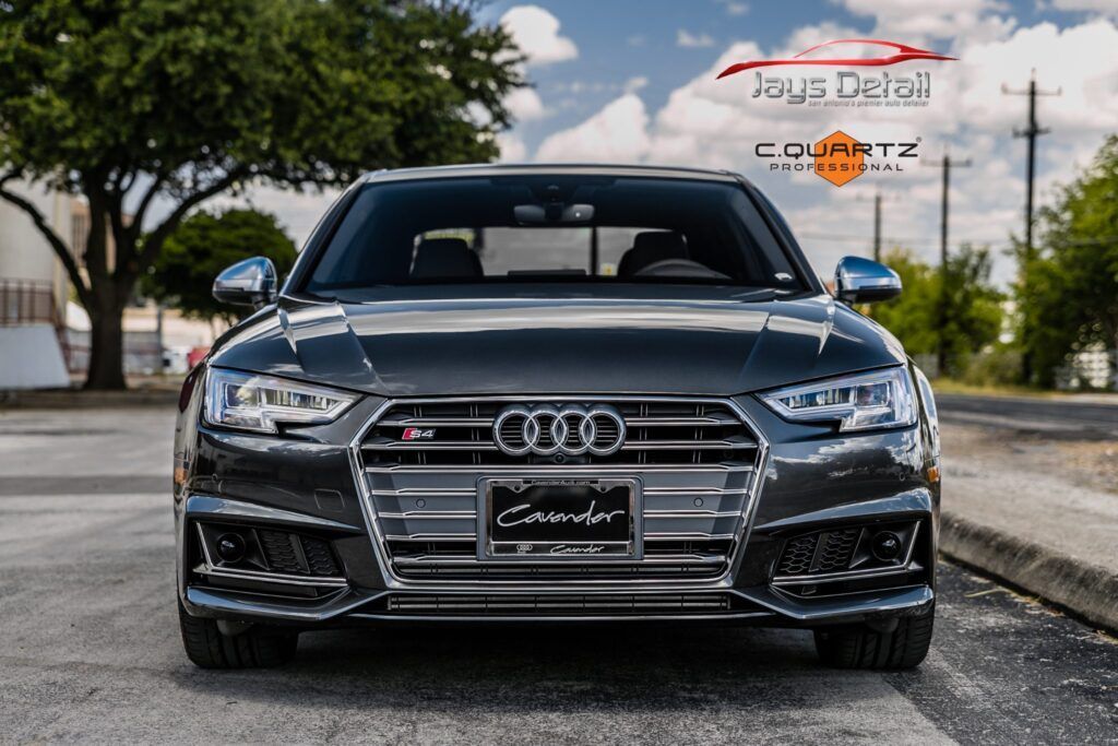 Dark grey Audi S4 sedan, front view, parked on a street.