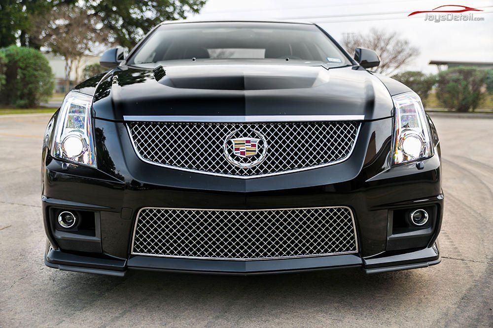 Black Cadillac CTS-V with chrome grille, front view, parked on pavement.