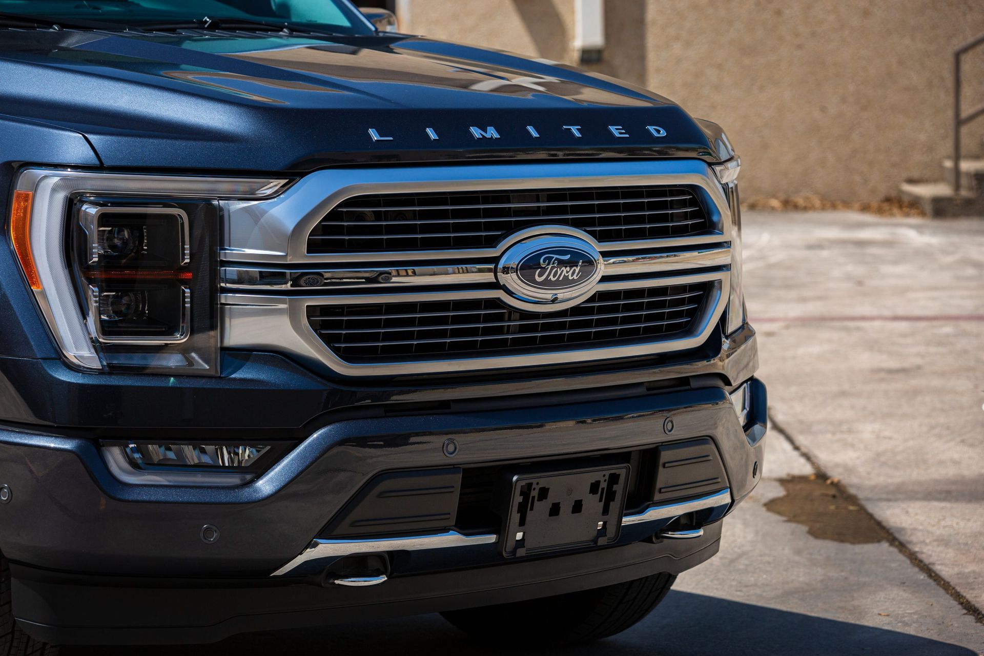 Front view of a blue Ford F-150 Limited truck with a silver grille, and