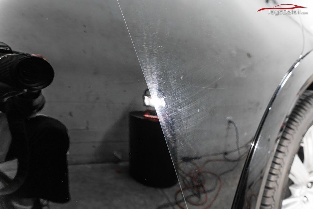 Car side panel, scratched black paint before and after polishing.