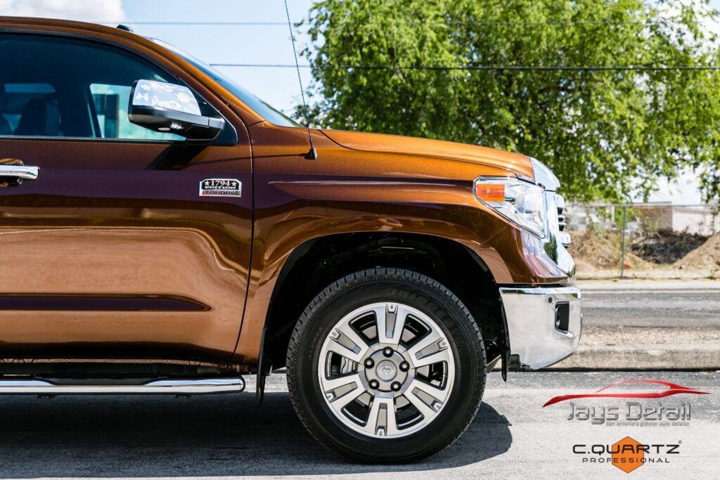 Brown Toyota Tundra truck, front view, chrome accents, parked on asphalt.