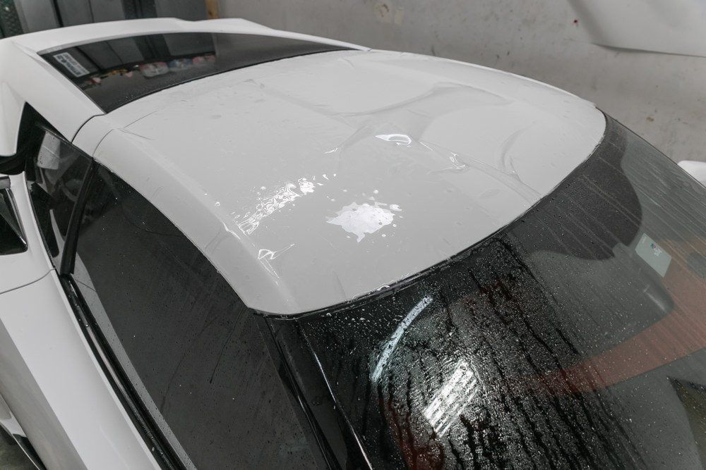 White car roof with water droplets.