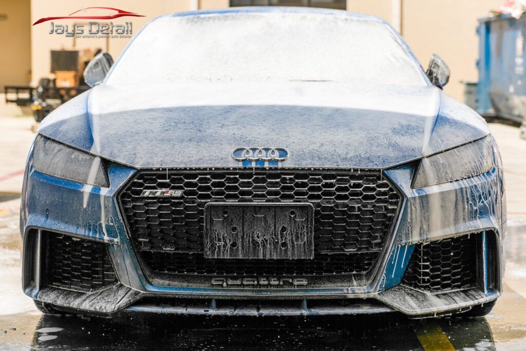 Blue Audi TT RS covered in soap suds, ready for detailing.
