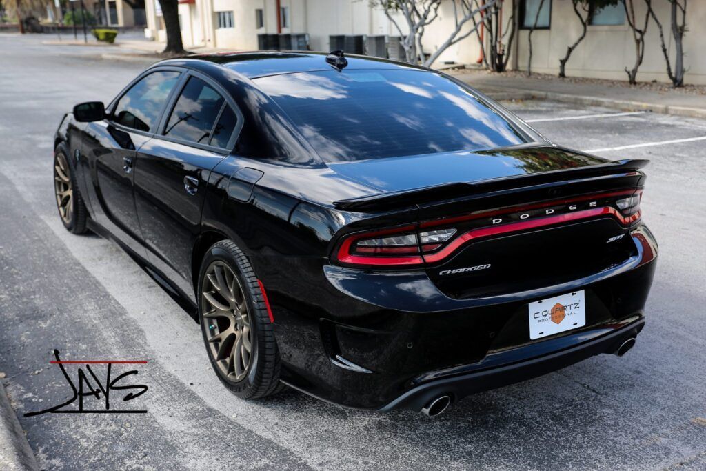 Black Dodge Charger SRT in a parking lot.