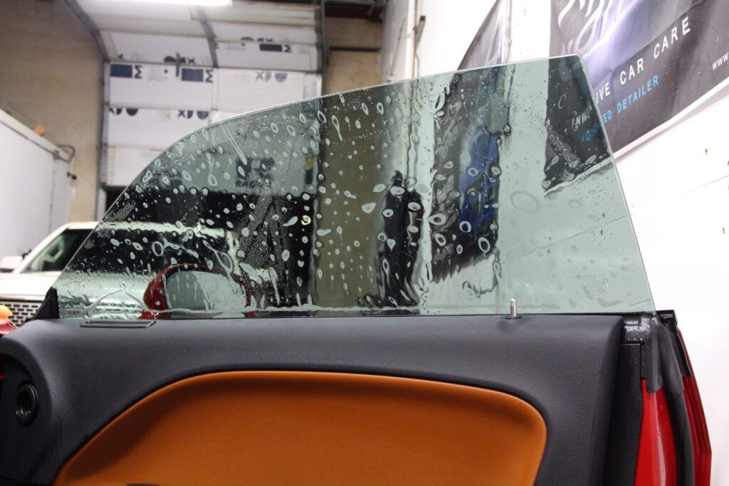 Car window being tinted, wet with soapy water. Brown door panel.