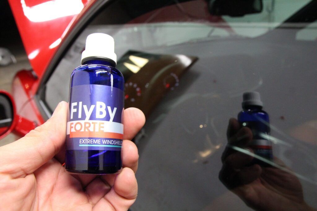 Hand holding a blue bottle of 