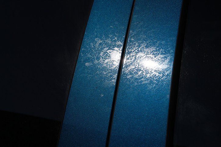 Two vertical strips of blue material with a glossy texture, reflecting bright light.