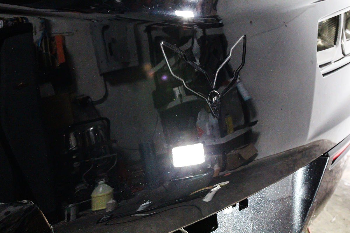 Black car bumper with a silver Corvette logo outline.