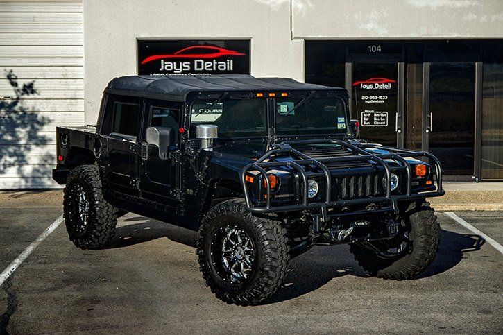 Black Hummer H1 parked in front of Jays Detail business with large off-road tires.