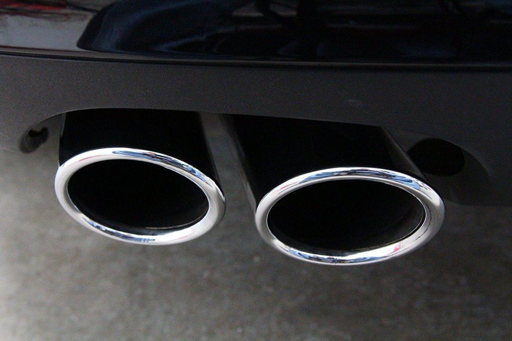 Two black car exhaust pipes with chrome trim.