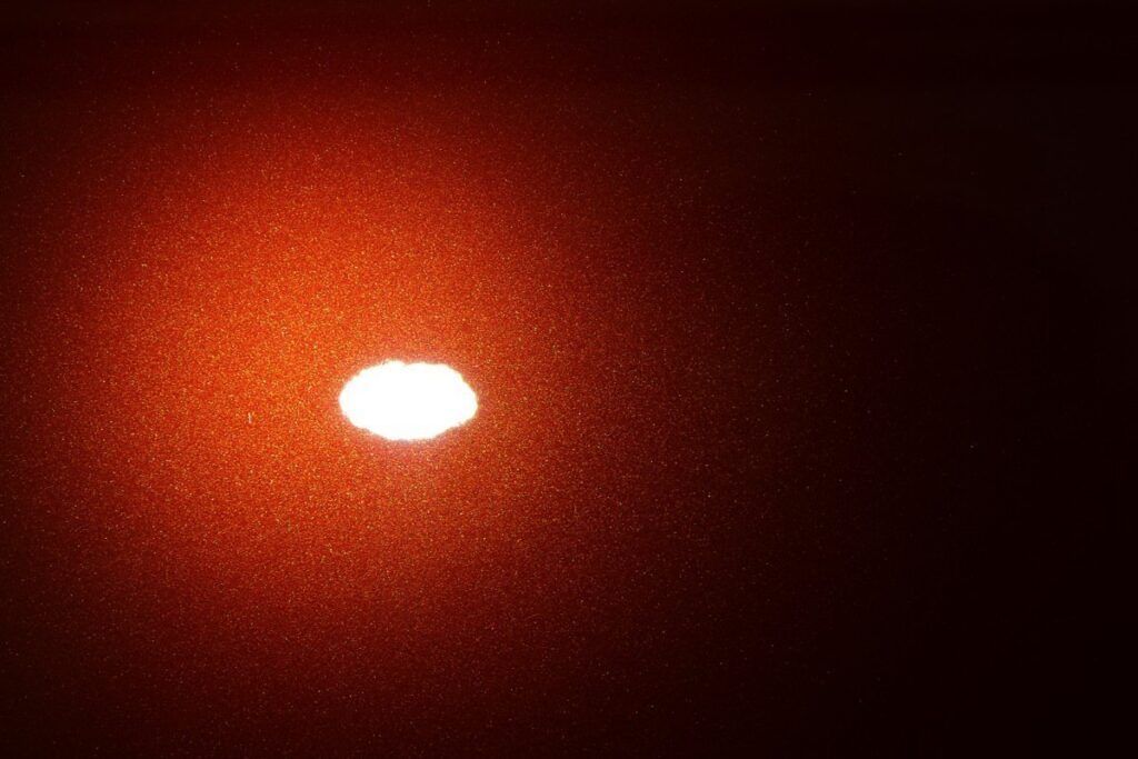 Orange and black gradient background with a bright white oval in the center.