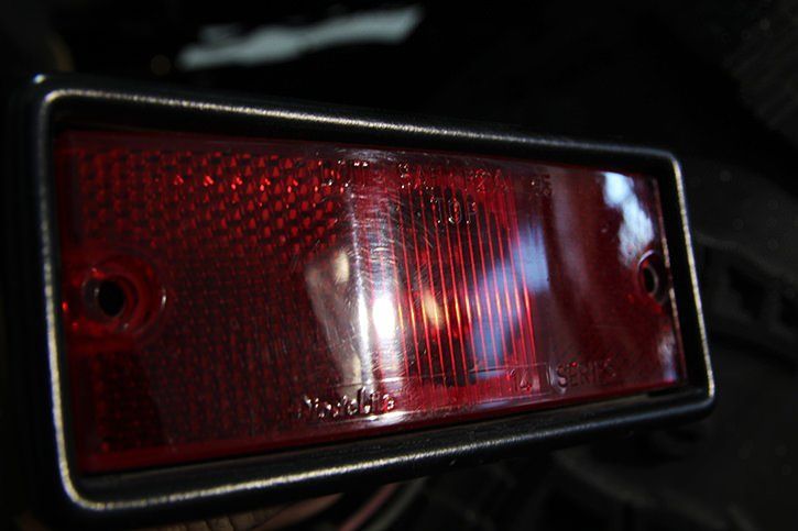 Red rectangular taillight with a black border and visible mounting holes.