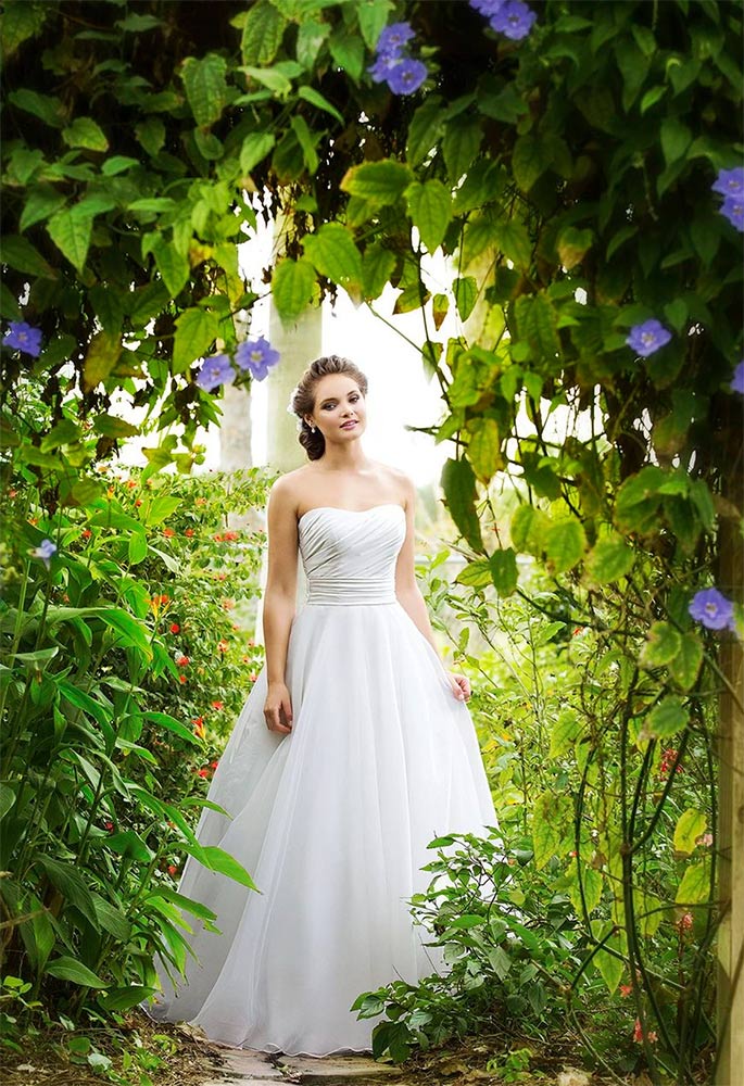 Femme sous une arche de feuillage et de fleurs violettes