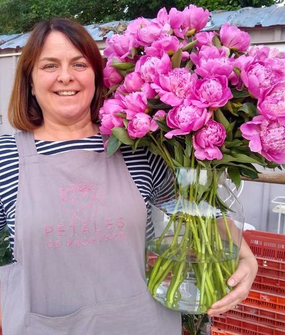 Debbie tenant un bouquet de pivoines roses