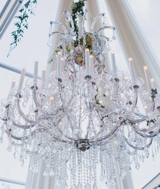 Lustre en cristal avec bougies et feuillage pour une réception de mariage