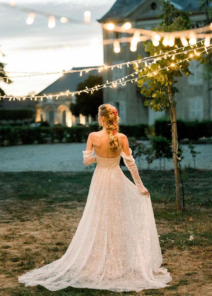 Guirlandes lumineuses installées pour une réception de mariage en extérieur