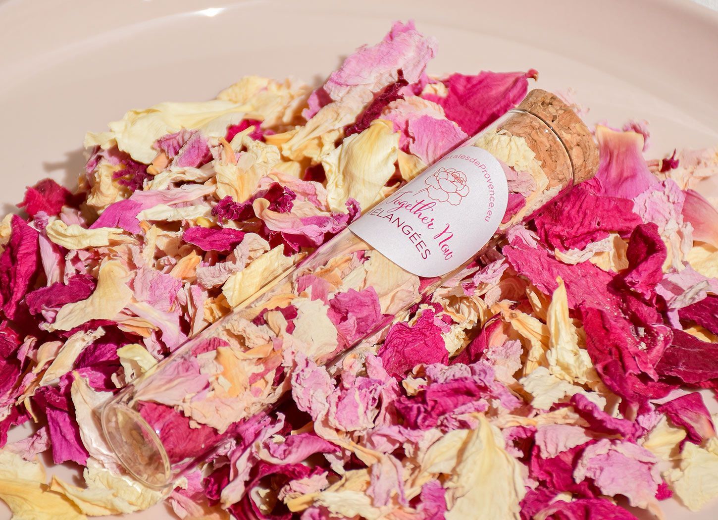 Mélange de pétales de pivoine séchés roses et crème avec un tube d’échantillon