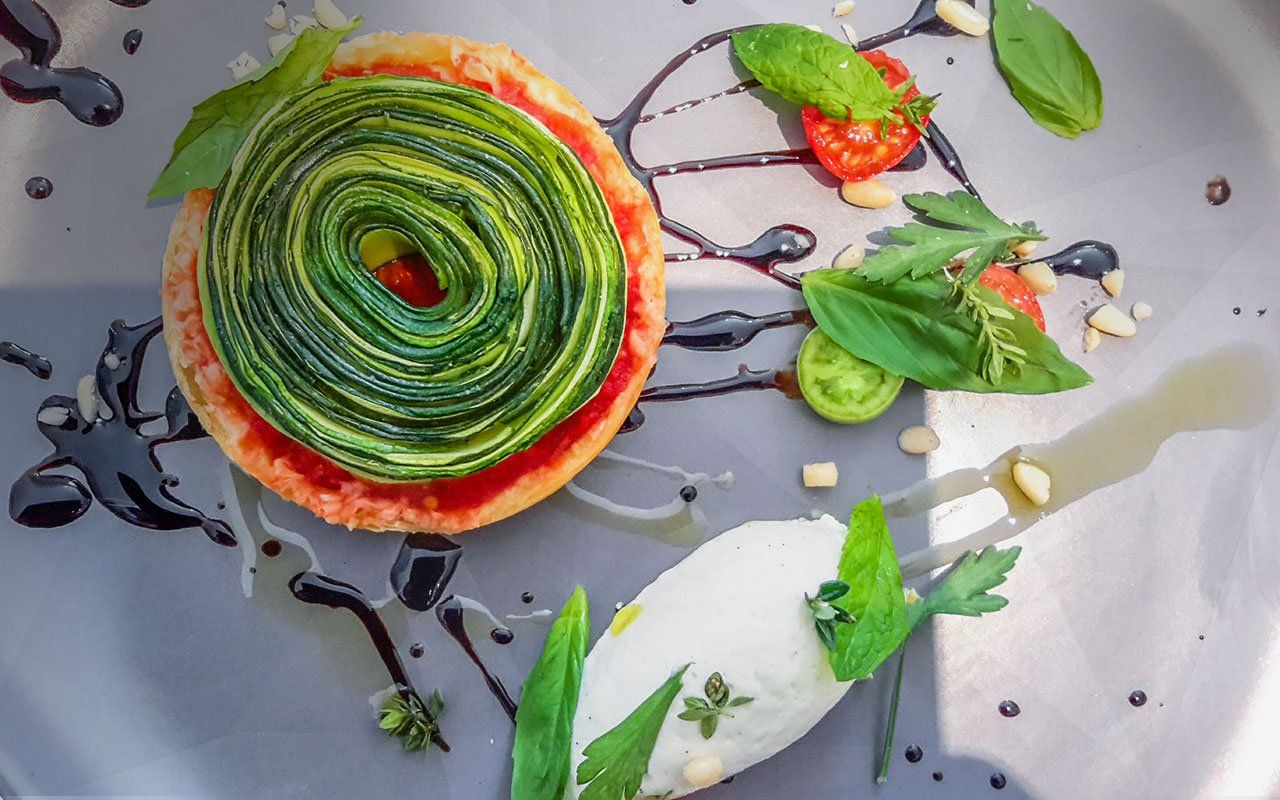 Tarte fine aux légumes verts accompagnée de mozzarella, basilic et tomates