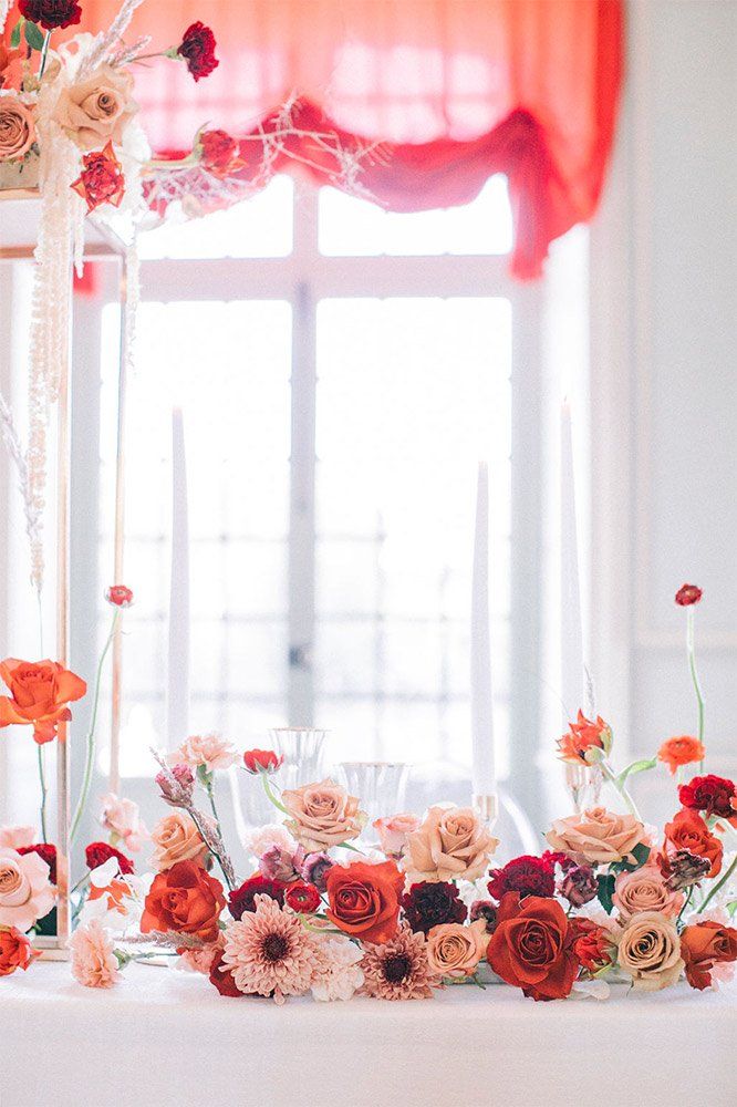 Décoration florale de mariage devant une fenêtre aux rideaux roses