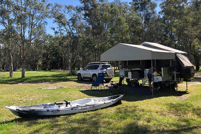 Explore The Wilderness With our Quality Camper Trailers, Featuring a Tent and Kayak in the Serene Forest Setting — Ozzie Camper Trailers in Aitkenvale, QLD
