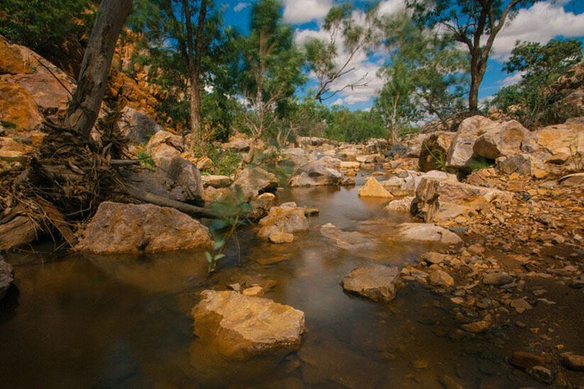 Tranquil Stream Winding Through Rugged Australian Landscape โ Ozzie Camper Trailers in Mount Isa, QLD