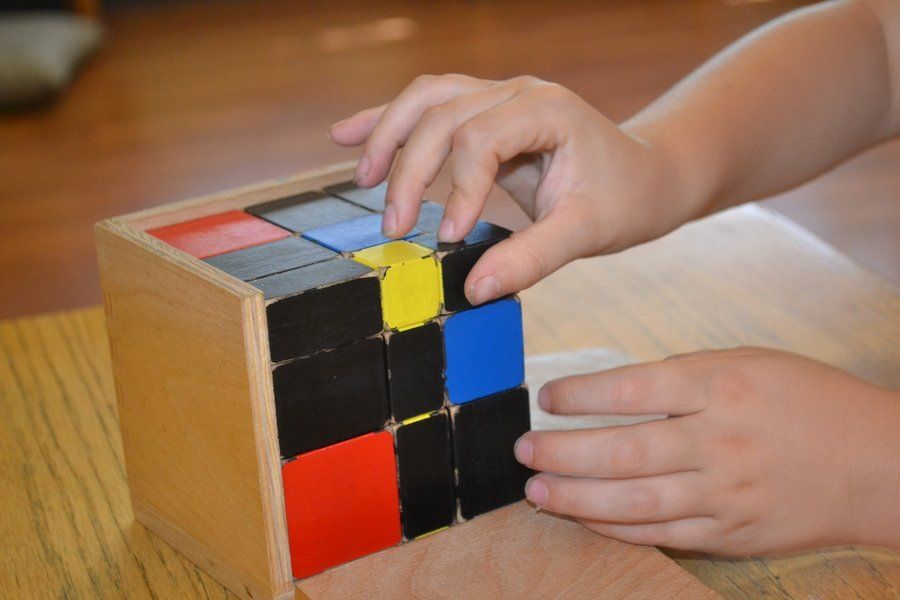 Montessori child working with the trinomial cube material