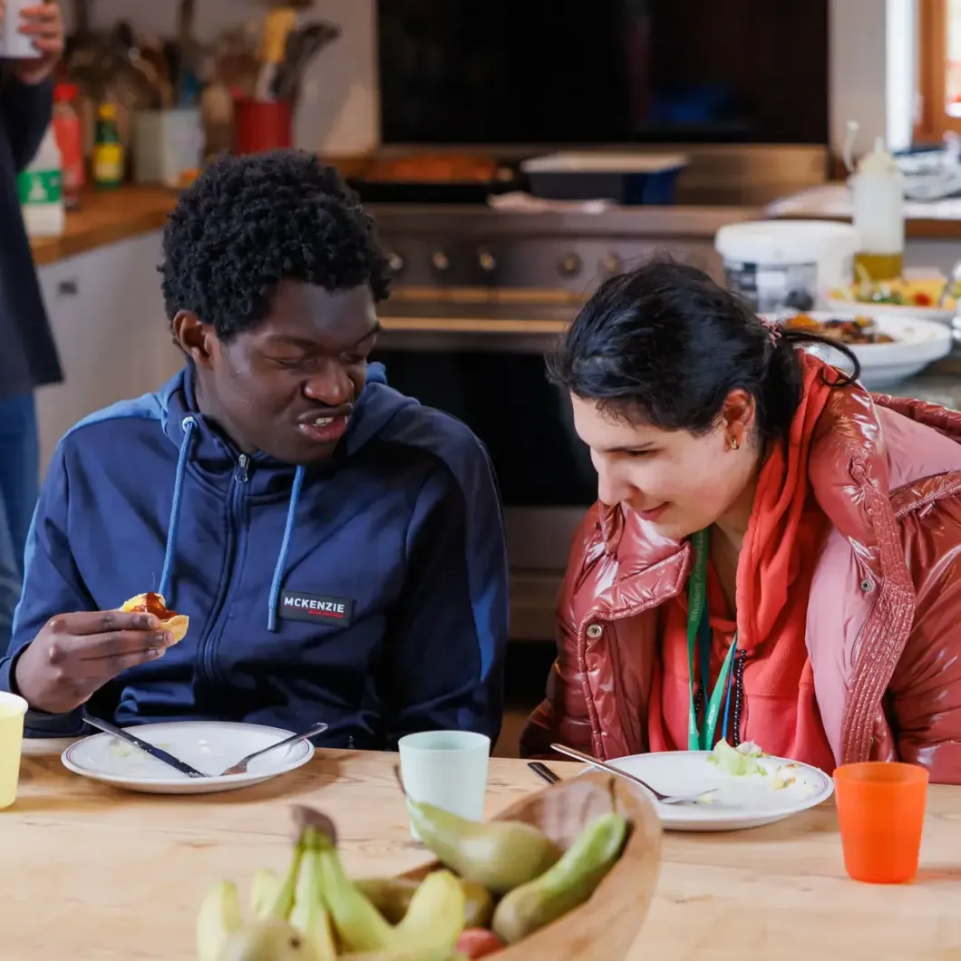 A man and a woman are sitting at a table eating food