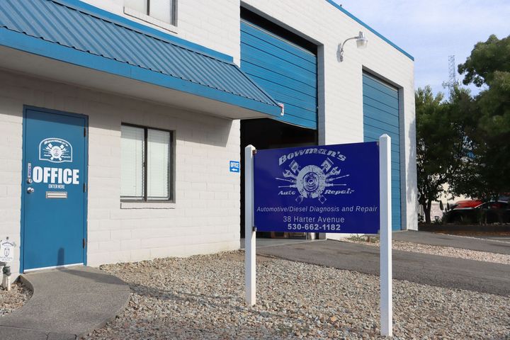 A blue sign in front of a building that says office