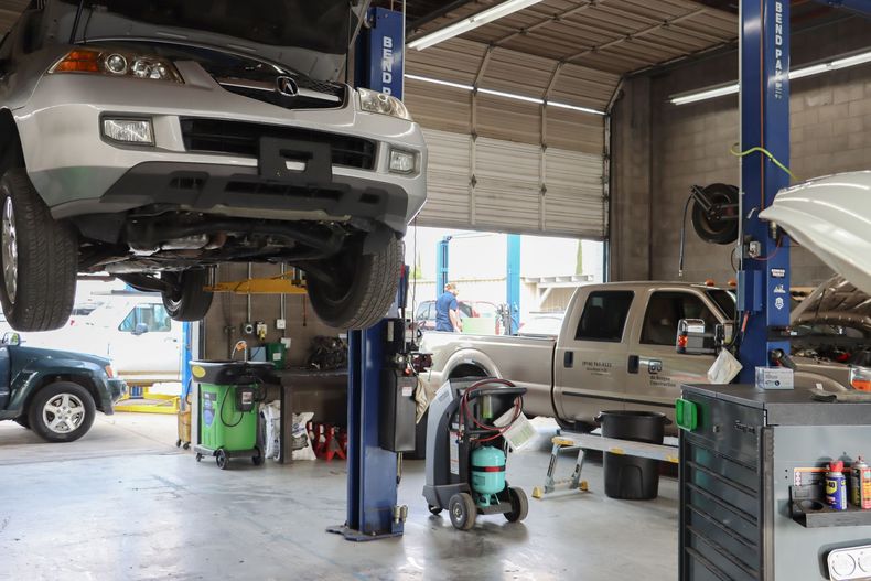 A car is sitting on a lift in a garage.
