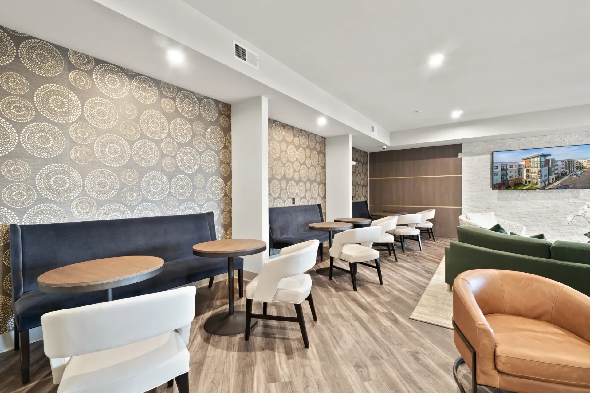 Lobby seating area with patterned wallpaper and modern furniture.