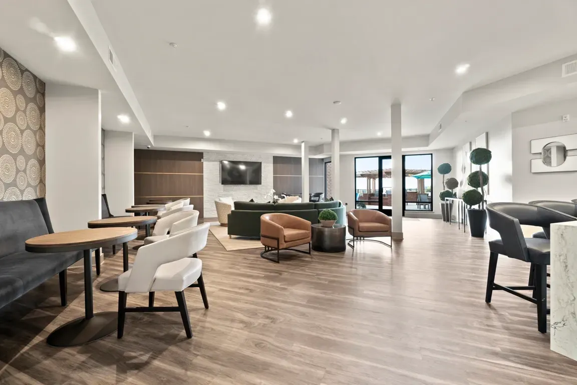 Modern lounge area with comfortable seating, tables, and a TV.