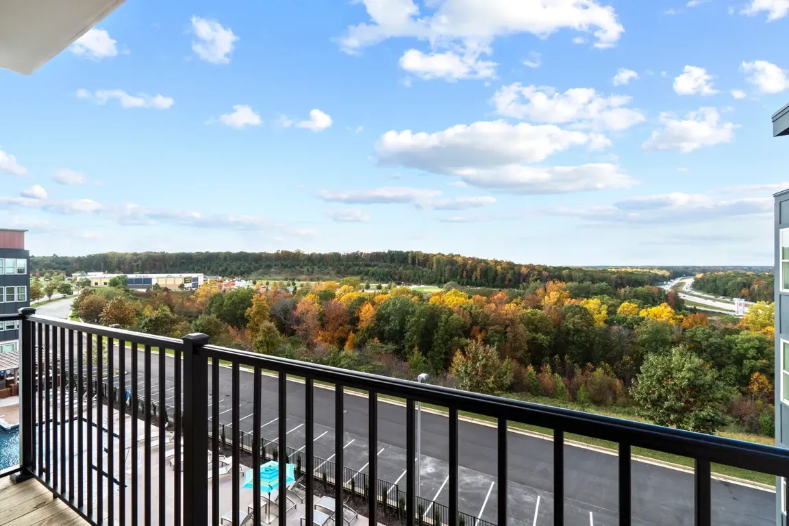 View of surrounding landscape from balcony with autumn foliage and highway in the distance.