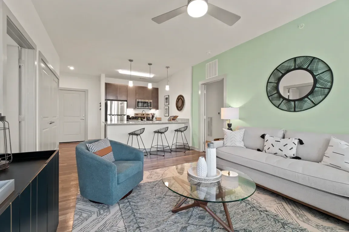 Living room and kitchen area of an apartment with modern furniture and decor.