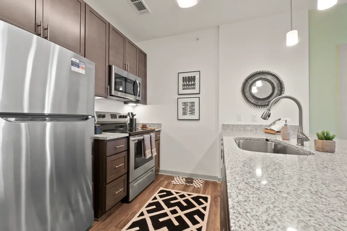Modern kitchen with stainless steel appliances, dark wood cabinets, and granite countertops.