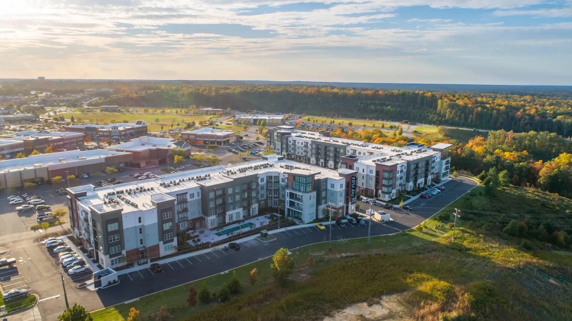 Aerial view of The Vue apartment complex with surrounding buildings and autumn foliage.