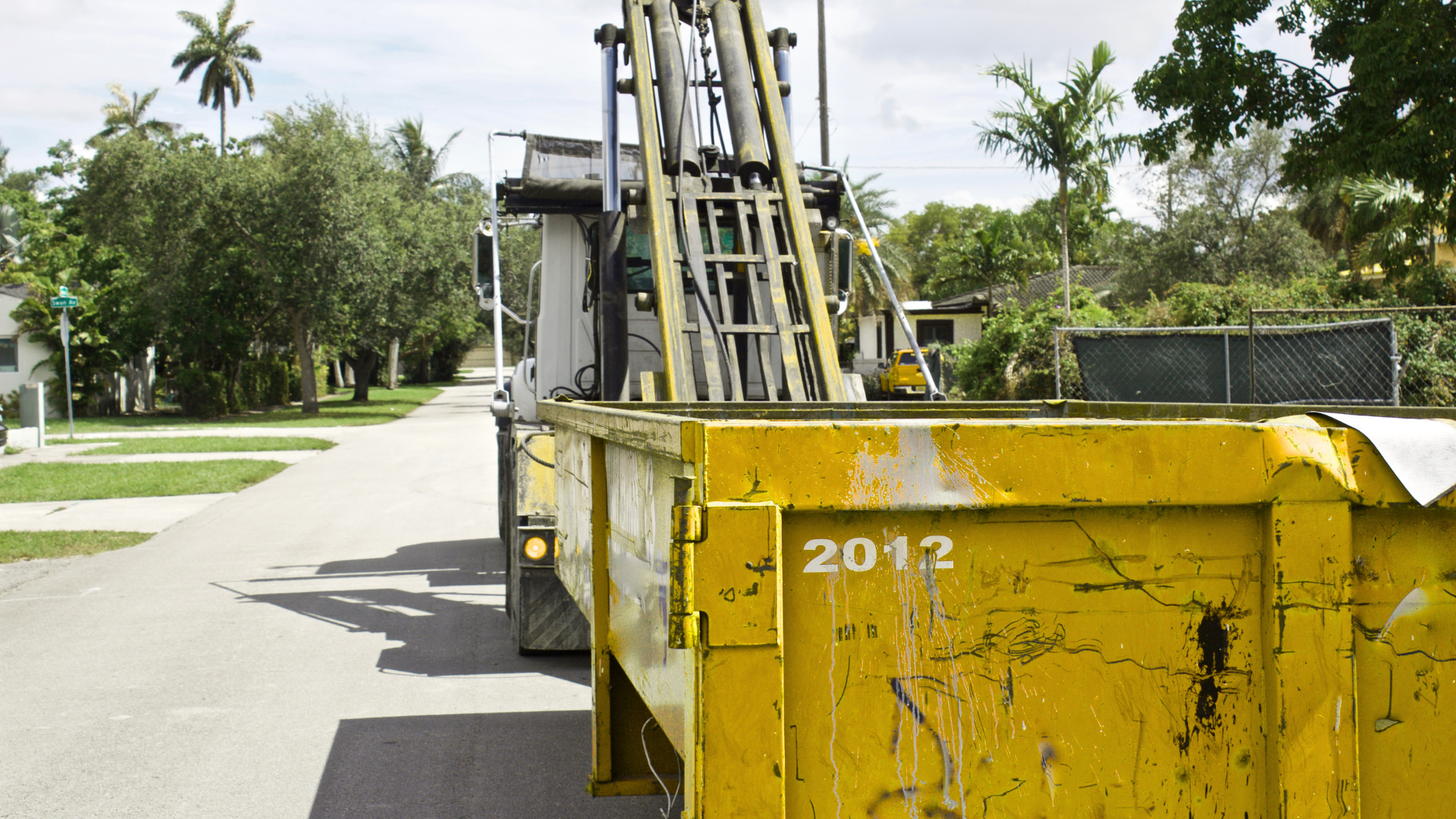 Dumpster truck delivering container to residential neighborhood