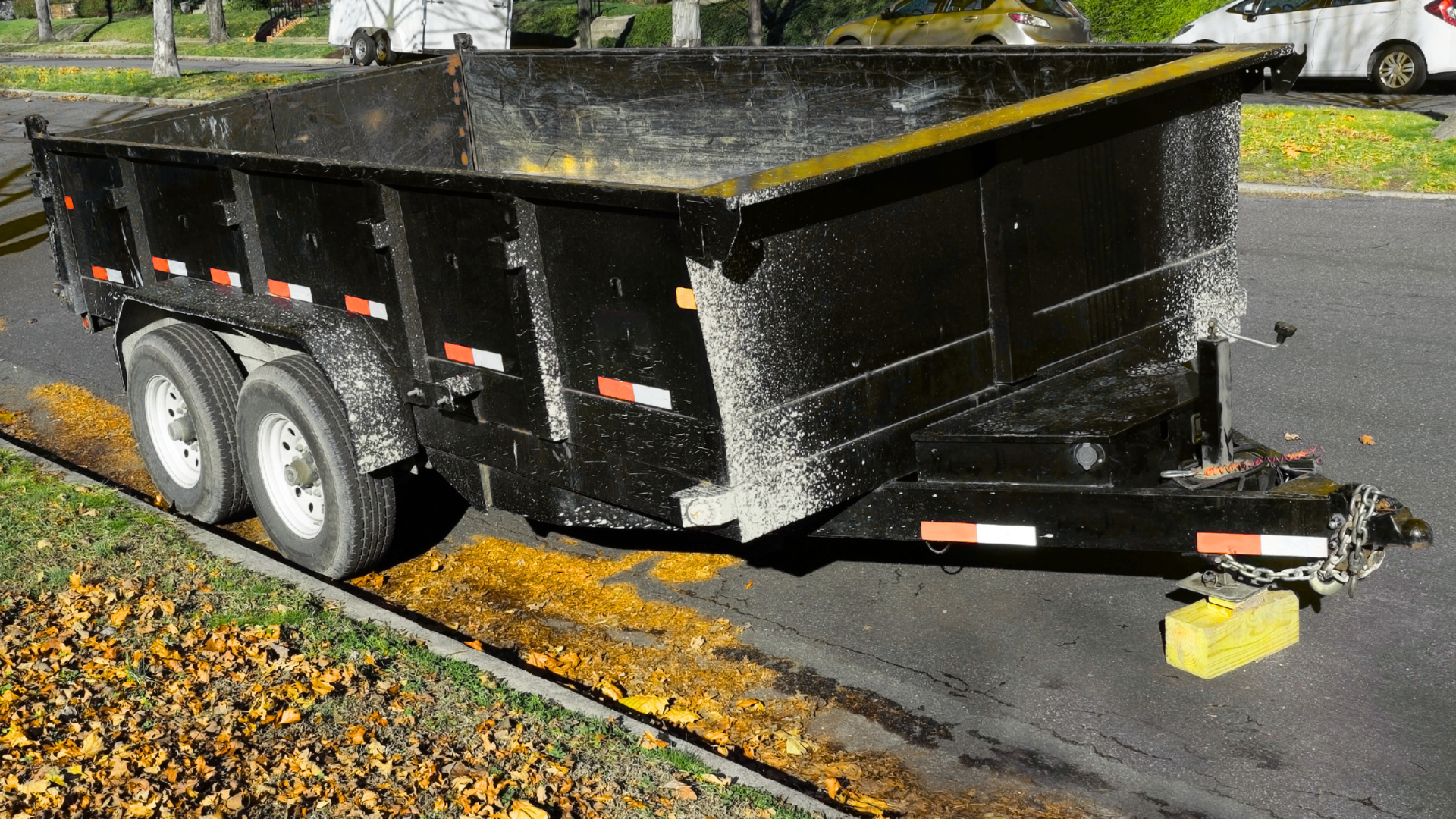Yard waste being disposed into residential roll off dumpster