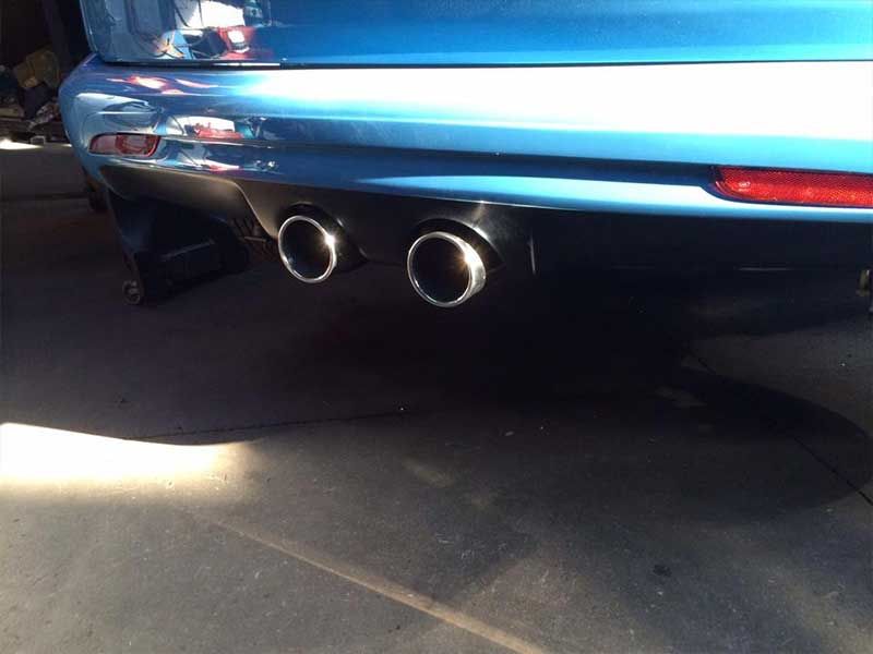 A Blue Car With Two Exhaust Pipes is Parked in a Garage — Hastings River Brake & Exhaust in Port Macquarie, NSW
