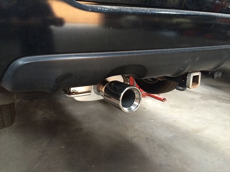 A Black Car With a Stainless Steel Exhaust Pipe Attached to It — Hastings River Brake & Exhaust in Port Macquarie, NSW