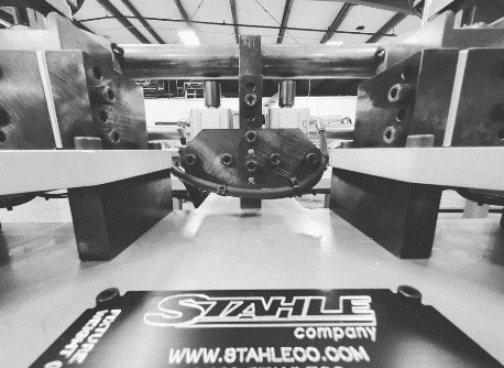 Machine with metal components bending a sheet, Stahle Company logo visible.