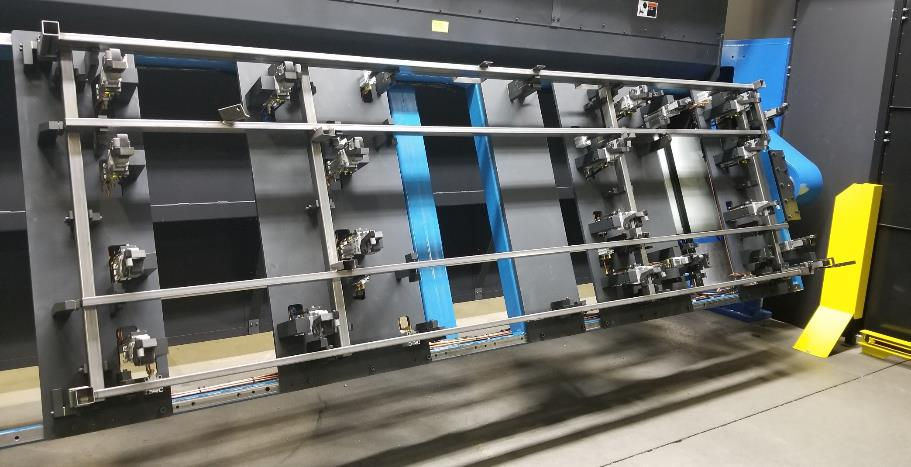 Large industrial machine with metal frame, blue panels, and many clamps.