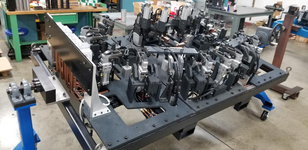 A complex industrial assembly with many components, possibly machinery, in a workshop setting.