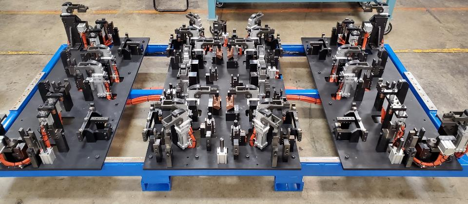 Industrial fixture with multiple components mounted on a blue frame.